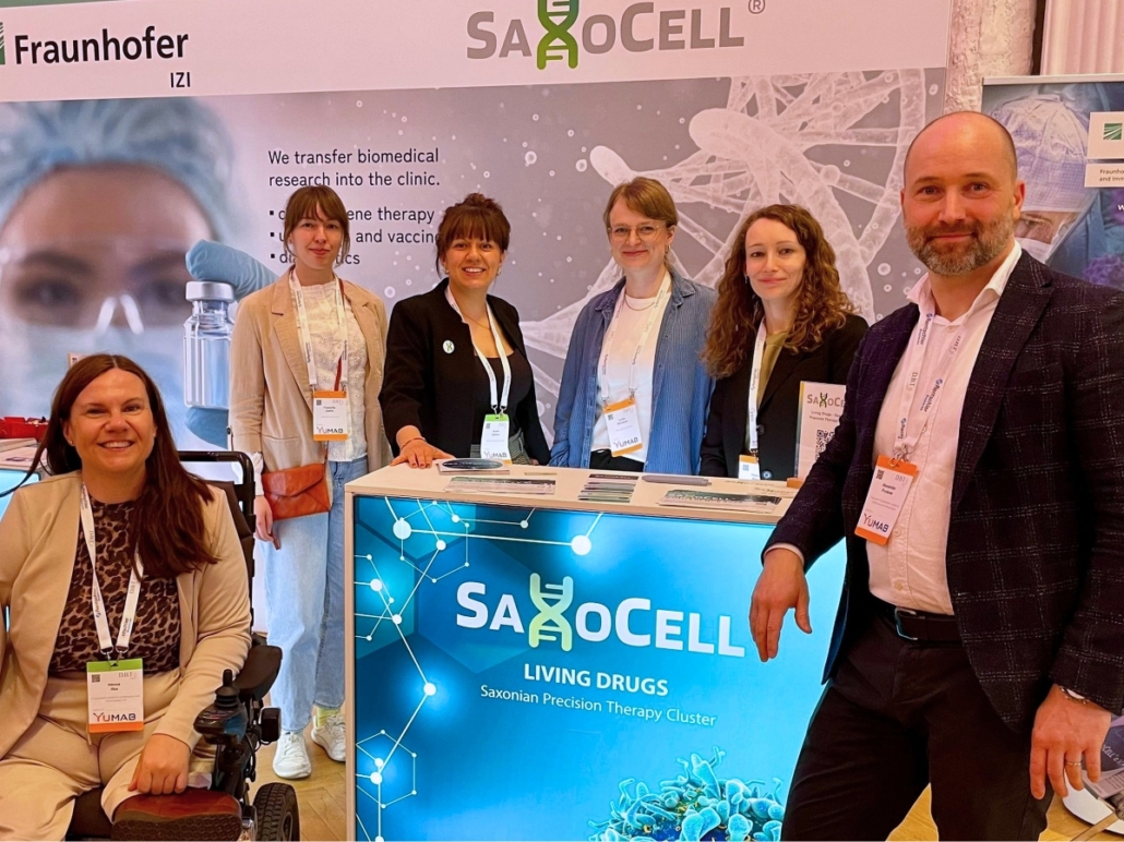 Group photo of the SaxoCell team at an exhibition booth during the German Biotechnology Days 2026 in Leipzig.
